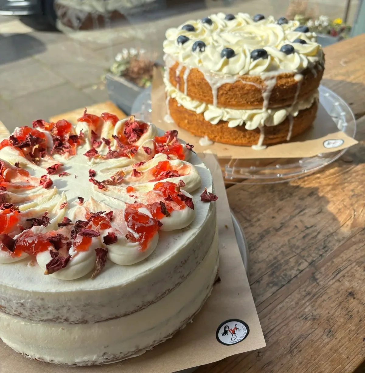 Two decorated layer cakes displayed in Kitchen91’s window